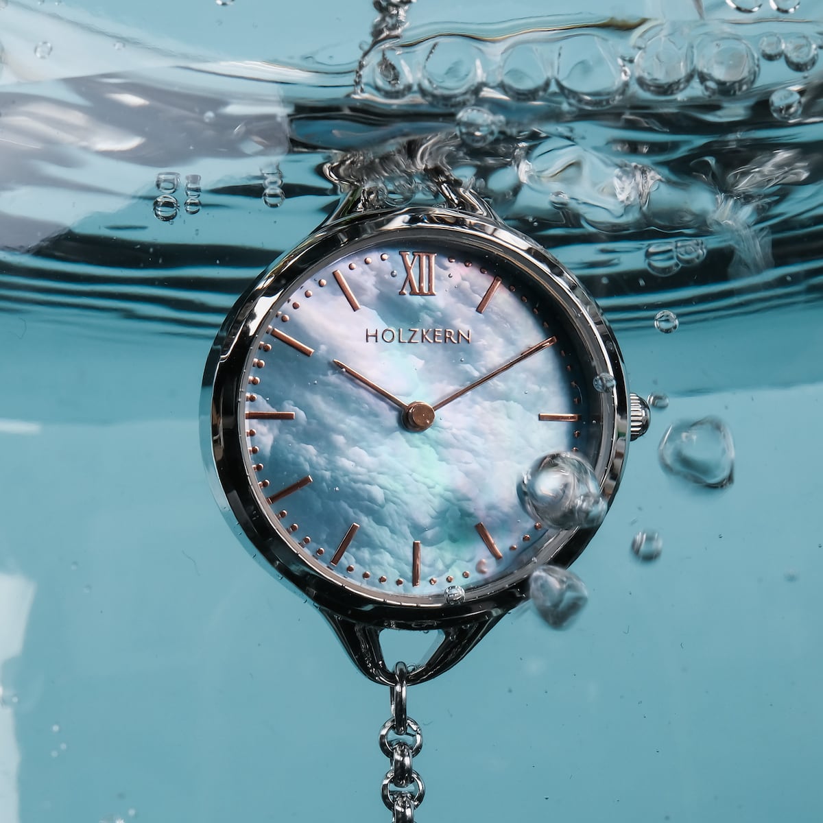 "Brighter" watch with nacre and silver styling, submerged in water.