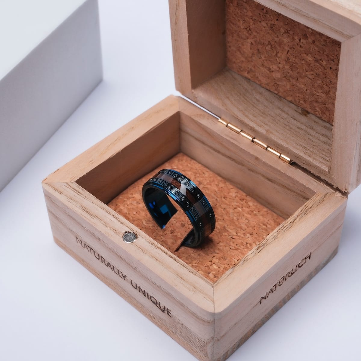 "Numerary Ring" ring featuring walnut and blue design, showcased in a wooden box.