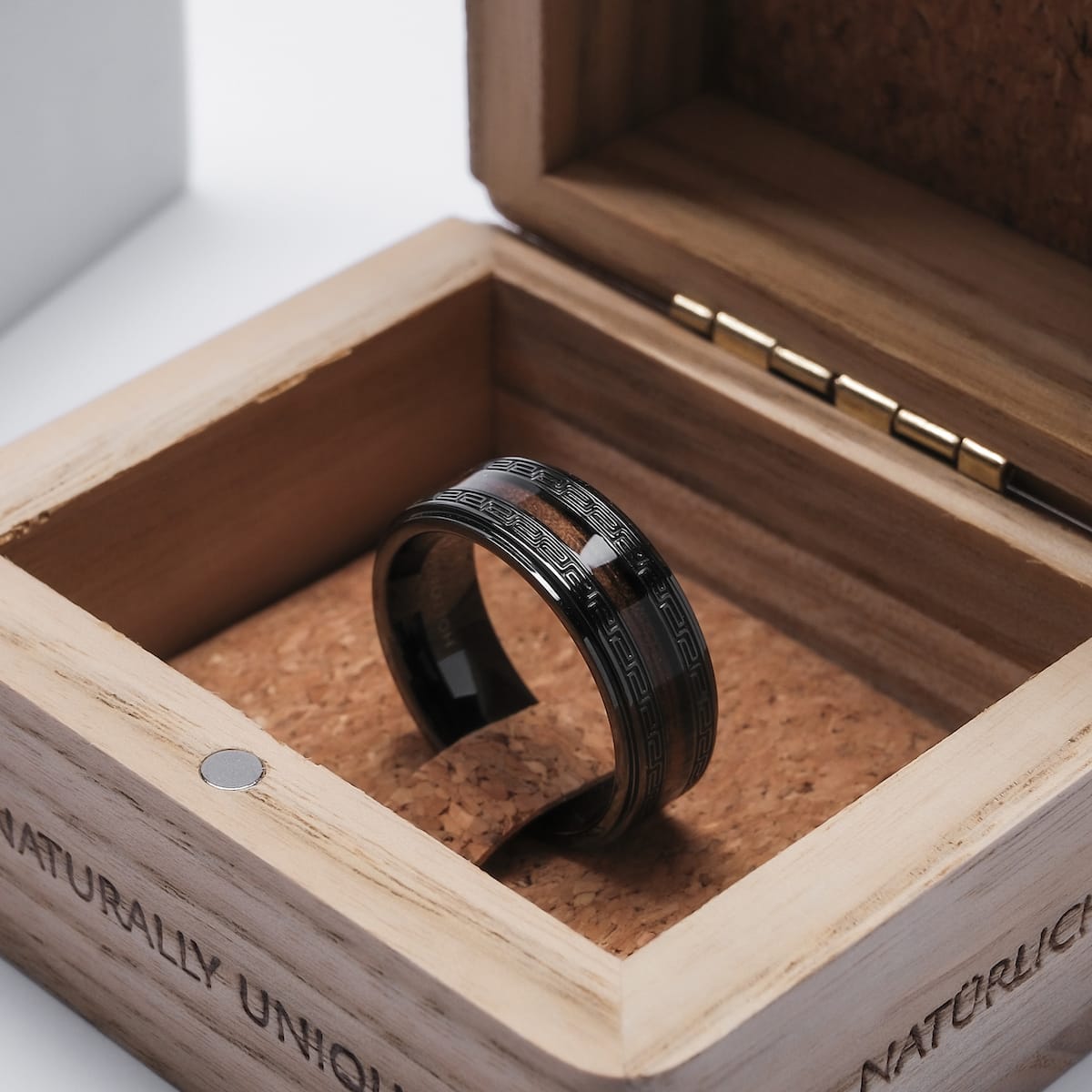 "Numerary Ring" ring with walnut and gray accents, showcasing an elegant, contemporary design in a wooden box.