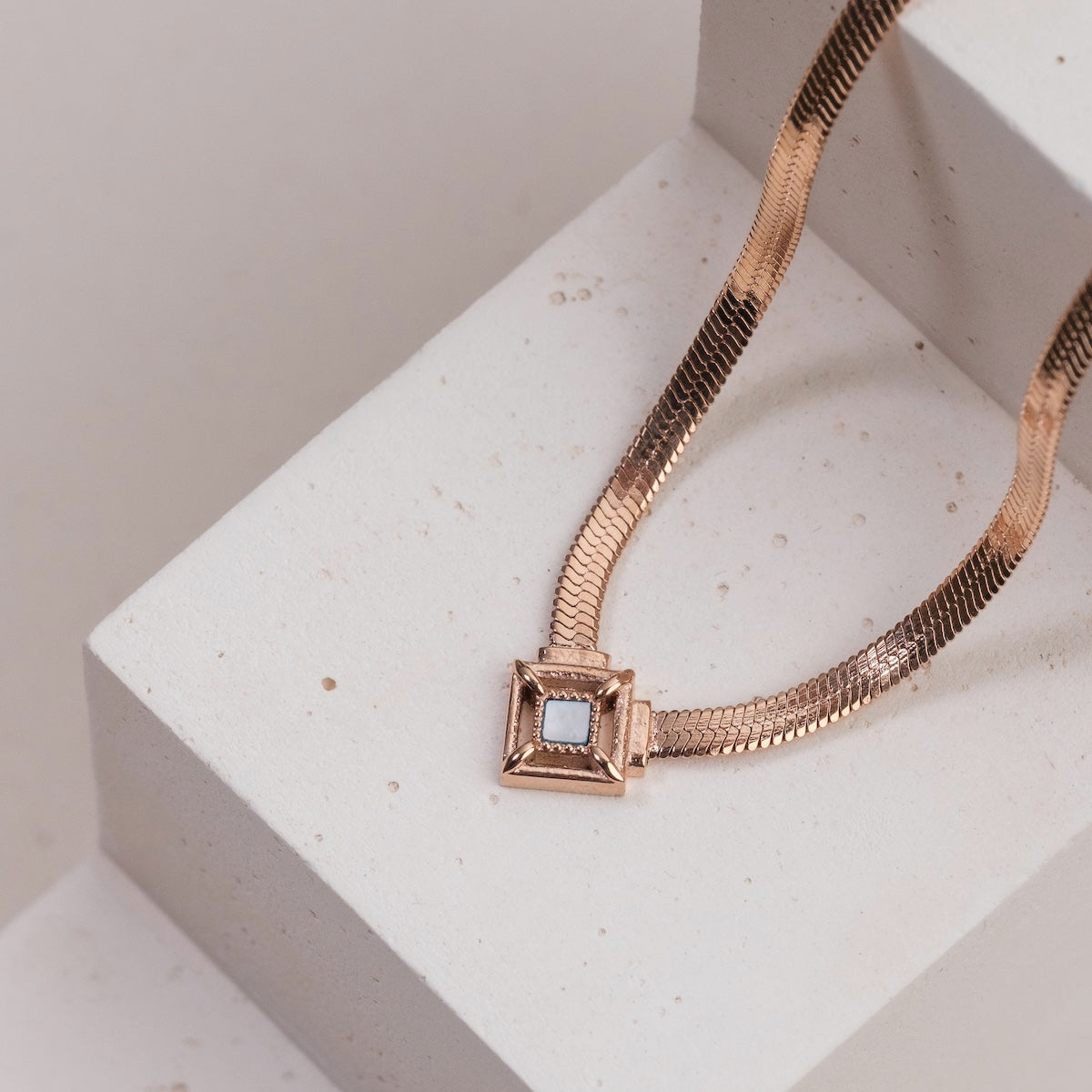 "Awakening Necklace", a rose gold necklace with a nacre accent and elegant design.