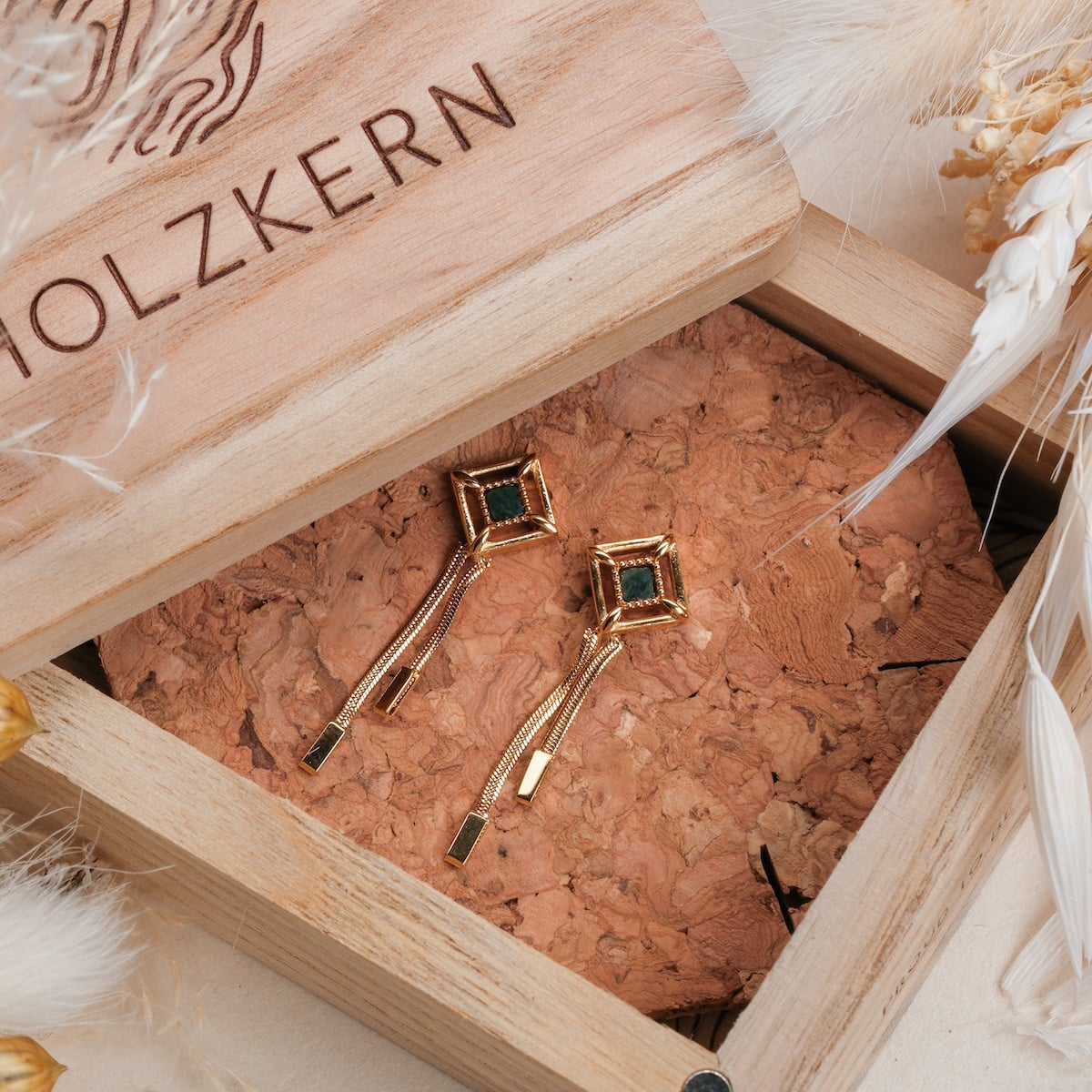 "Awakening Earrings" earrings feature a marble and gold design with a modern, elegant style.