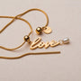 "Love-Charm" necklace featuring elegant gold finish and pearl accent in a stylish design.