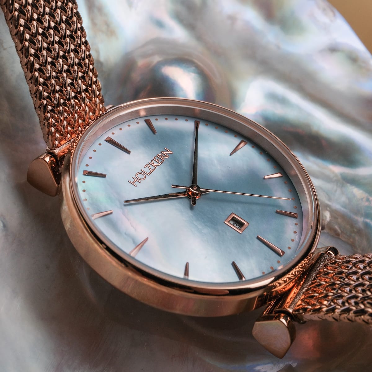"Chitchat" watch features a nacre dial with rose gold accents and a mesh band for an elegant and stylish look.