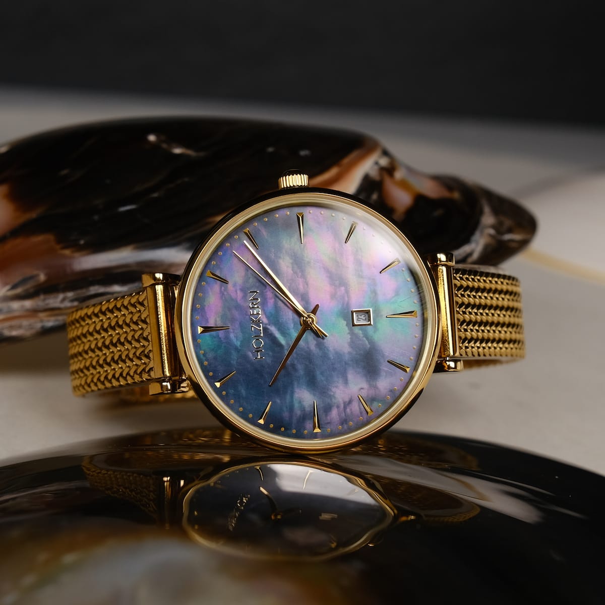 "Giggles", an elegant watch with a nacre and gold design, showcasing a luxurious and timeless visual style.