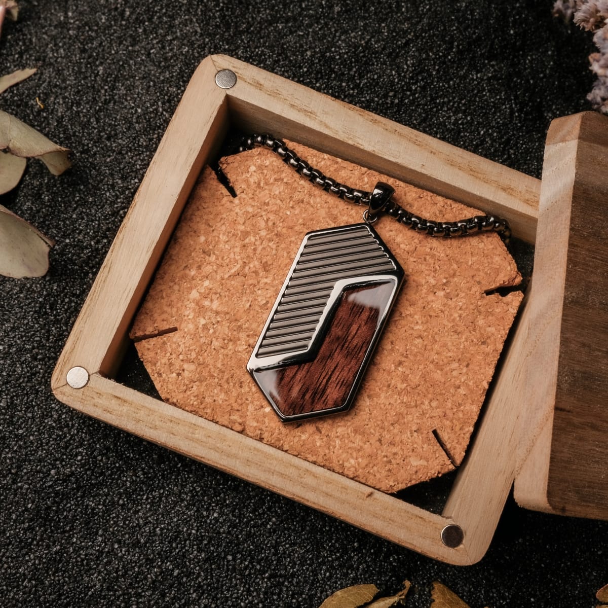 "Zigzag Necklace" necklace featuring a geometric design with walnut and dark gray accents, displayed in an open wooden box.