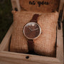 "Shirin", elegant watch in walnut/rose gold with a classic leather band, displayed in a rustic box.