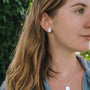 "Aquarell Earrings" earrings with a modern white nacre and silver design, elegantly worn by a woman.