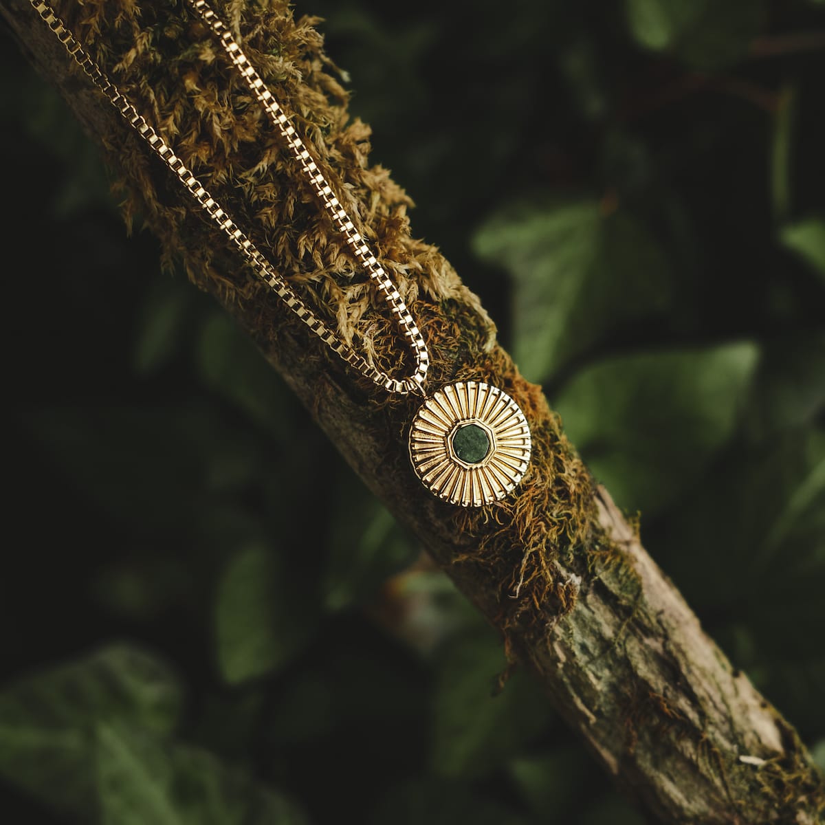 "Stencil Necklace", a stylish necklace featuring a marble center and gold accents, displayed against a natural background.