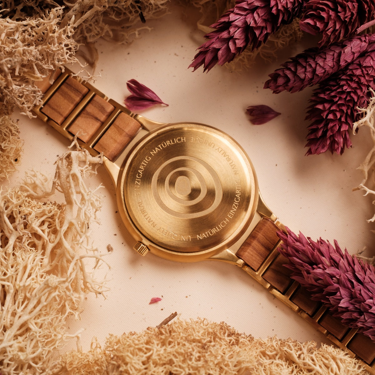 "Capri" watch, featuring a natural wood and gold style, elegantly surrounded by dried botanicals.