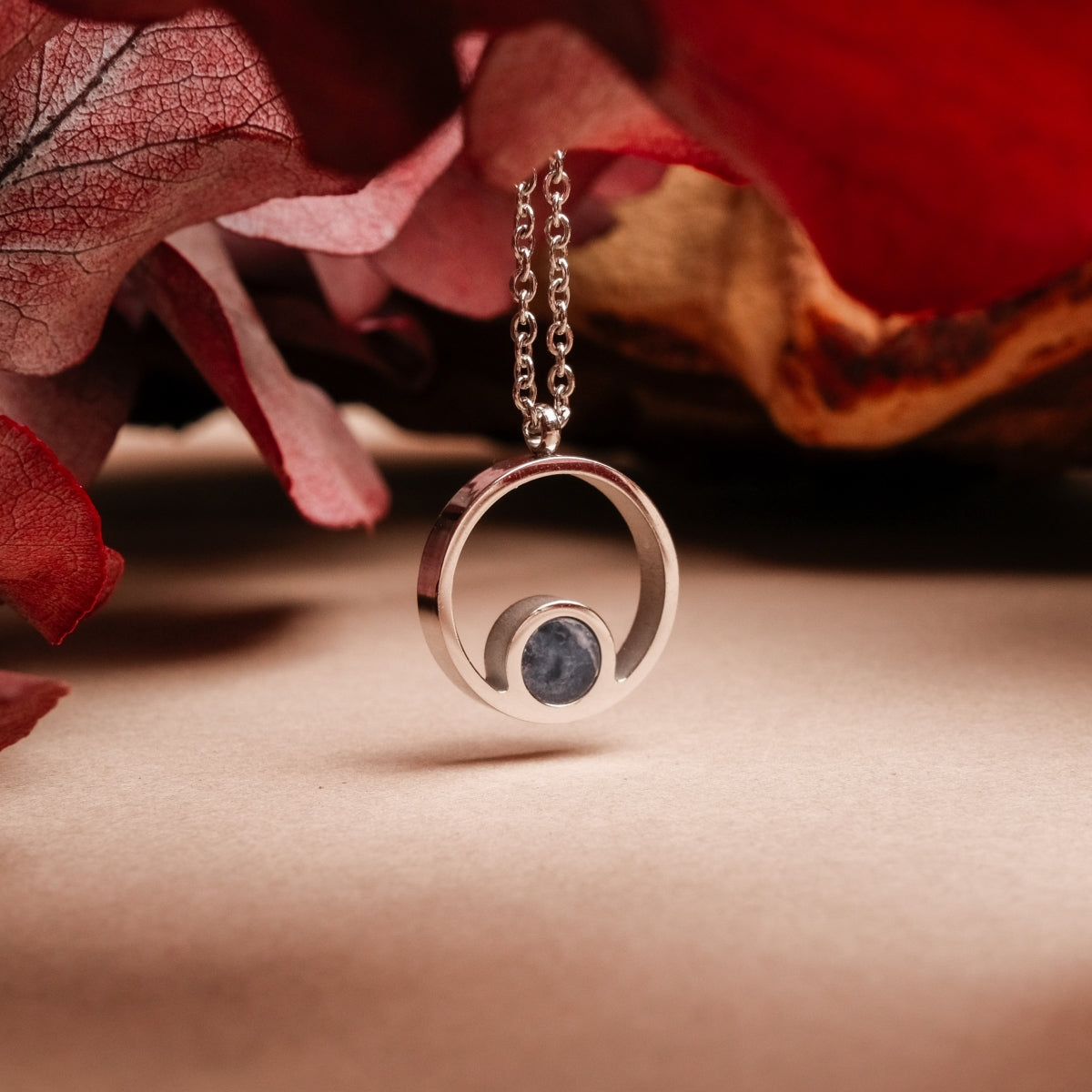 "Pigment Necklace": A stylish, circular marble and silver necklace with elegant design features.