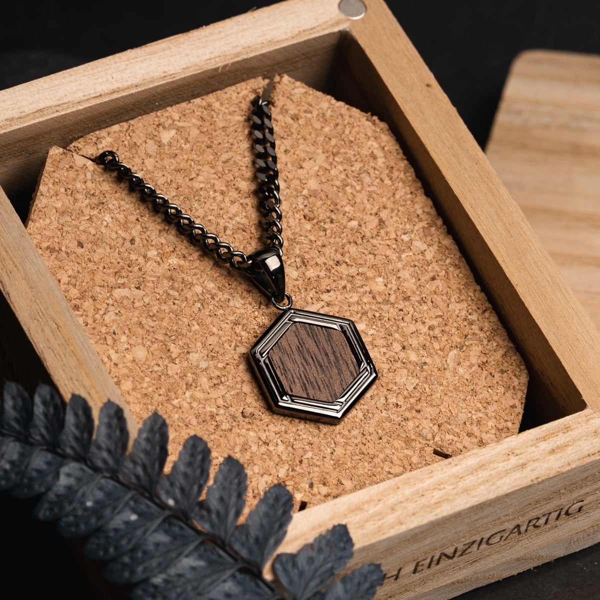 "Axis Necklace" necklace featuring a walnut insert and dark gray chain in a hexagonal design.