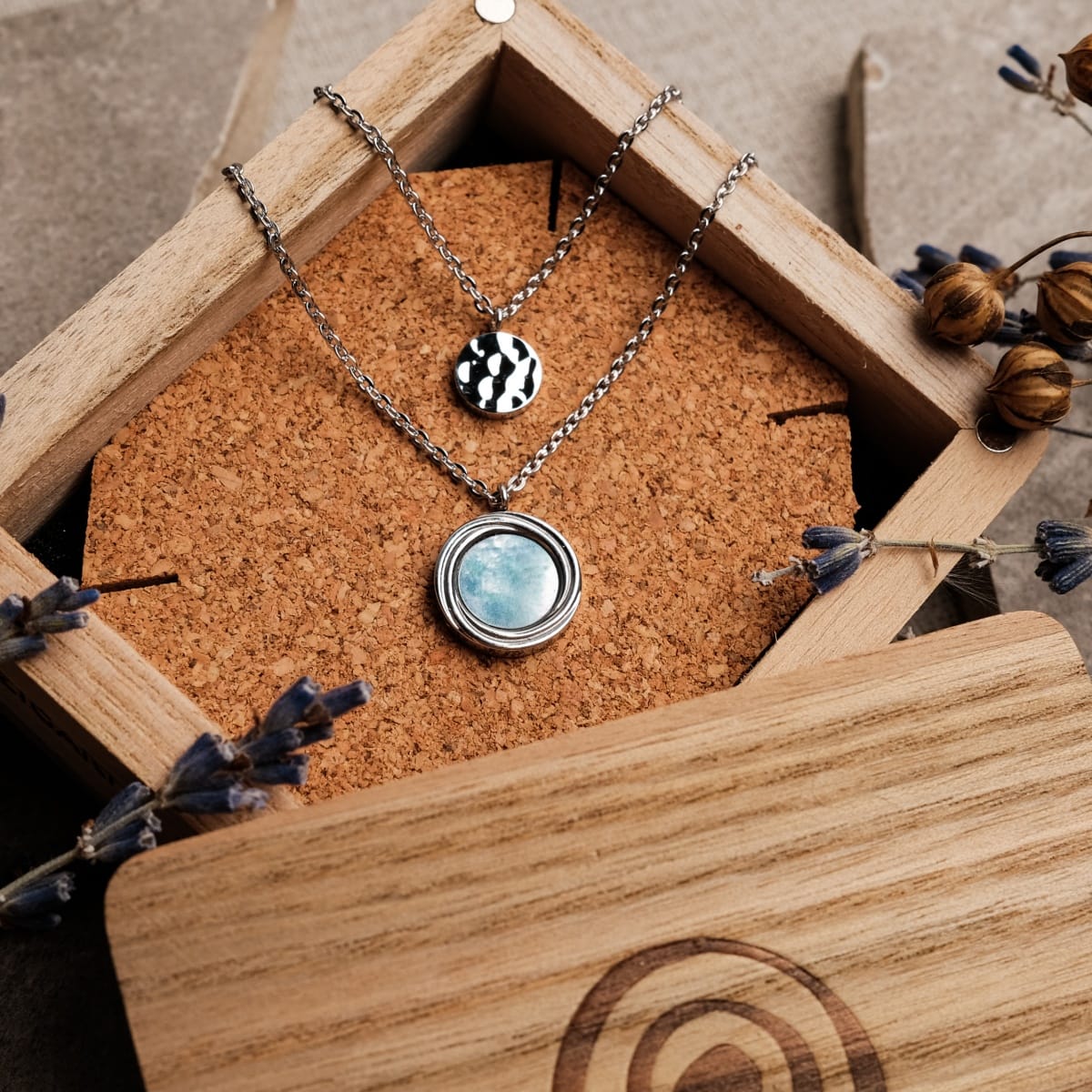 "Zendala Necklace" - A stylish necklace with nacre and silver design, elegantly presented in a wooden box with floral accents.