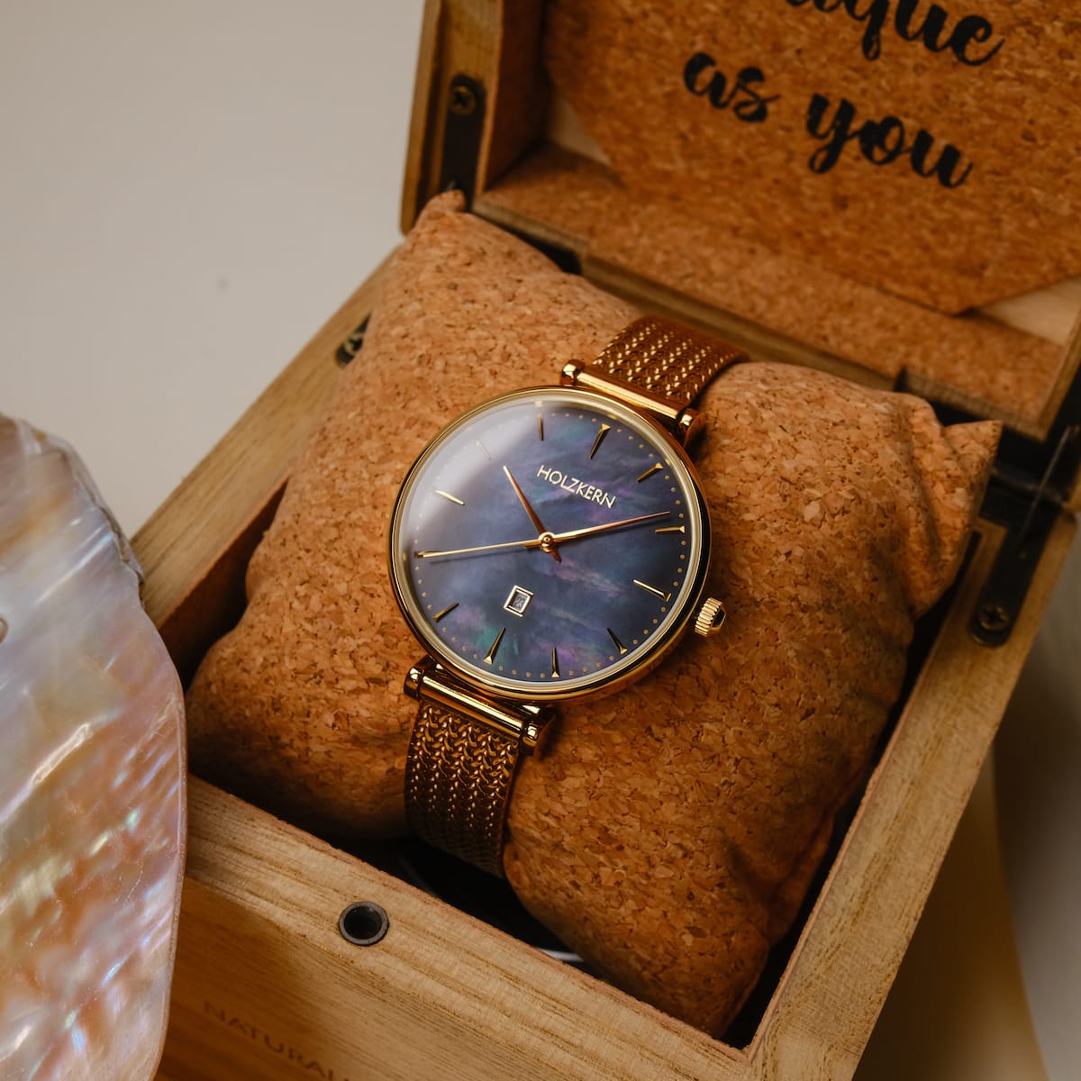 "Giggles" watch featuring a nacre dial and gold mesh band presented in an elegant wooden box.