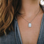 "Aquarell Necklace" necklace featuring a white nacre pendant with a silver setting, showcasing an elegant and minimalist design.