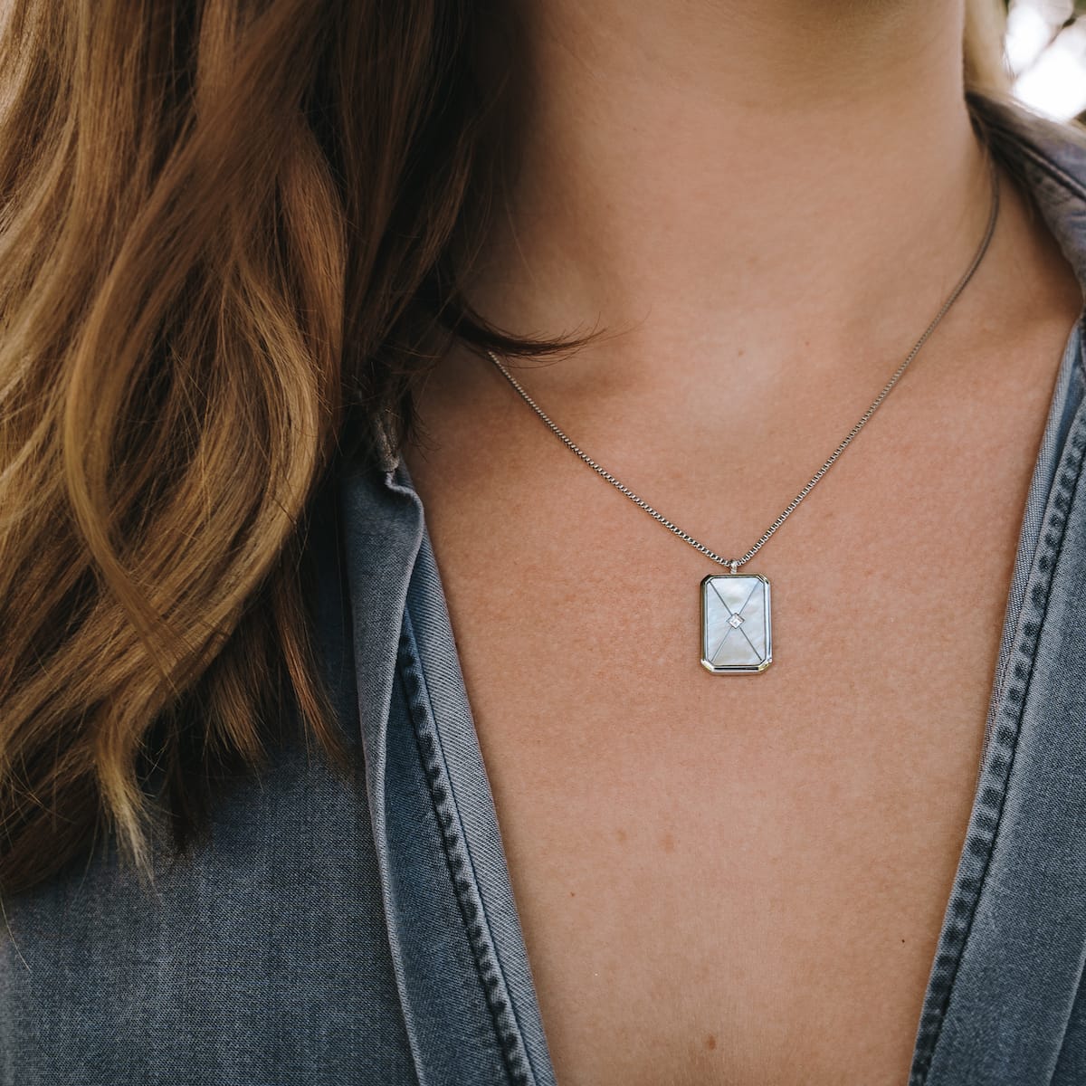 "Aquarell Necklace" necklace featuring a white nacre pendant with a silver setting, showcasing an elegant and minimalist design.