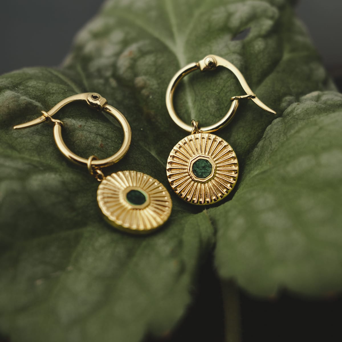 Stencil Earrings, elegant earrings with a marble and gold design showcased on a leaf background.