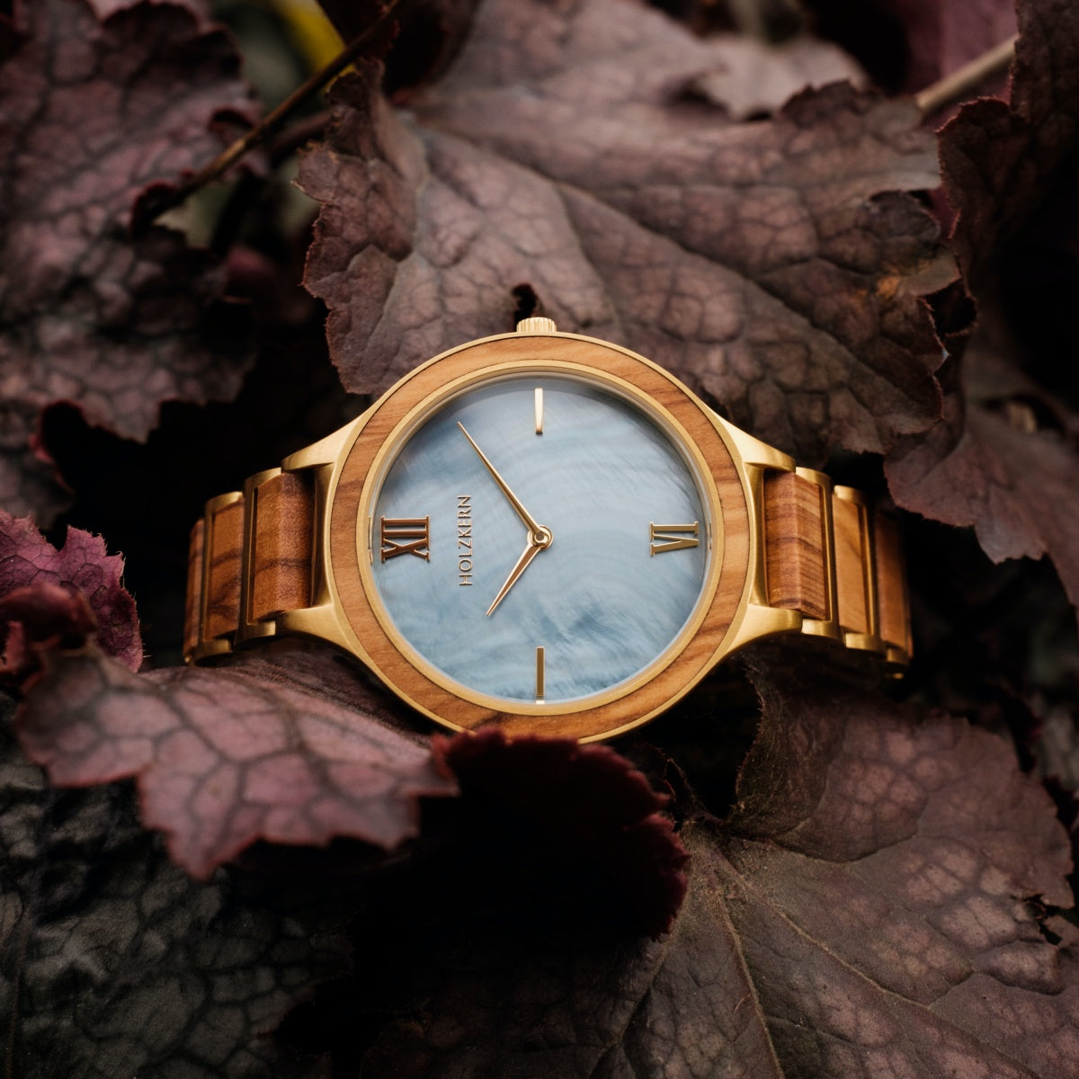 "Capri" watch featuring a natural wood finish and elegant design among rich foliage.