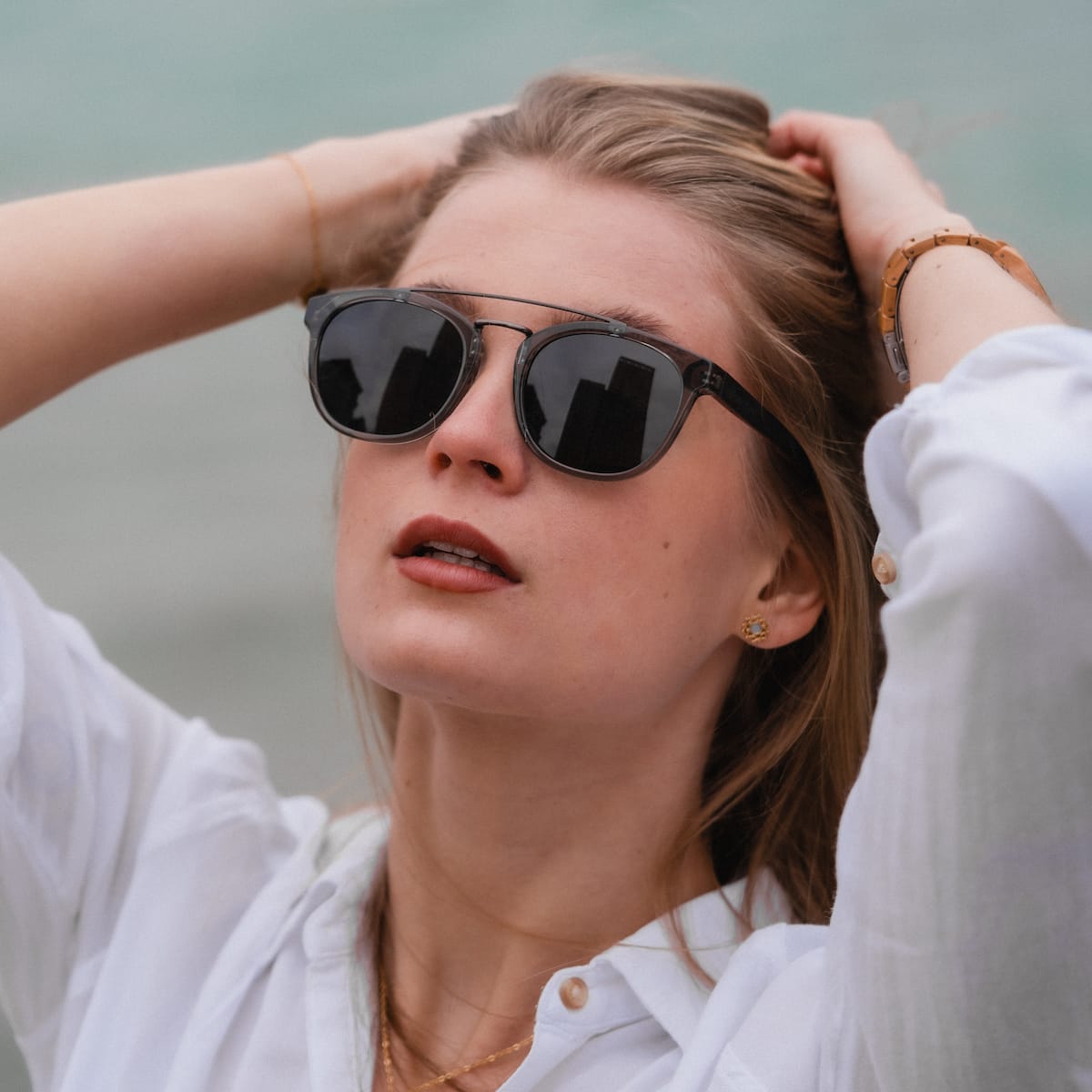 "The Trustworthy" sunglasses with a sleek, modern style featuring dark lenses and an elegant frame design.