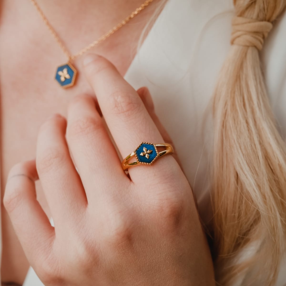 "Spectral Ring": Gold ring with a blue nacre design, featuring a modern hexagonal style.