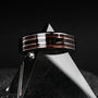 "Cartesian Ring", a modern ring with walnut and silver accents, displayed on a geometric glass surface.