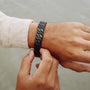 "Baritone" bracelet in marble and black, showcasing a sleek, modern design on the wrist.