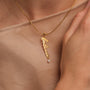 "Believe-Charm" necklace, a gold charm with a pearl accent and a sleek script design.