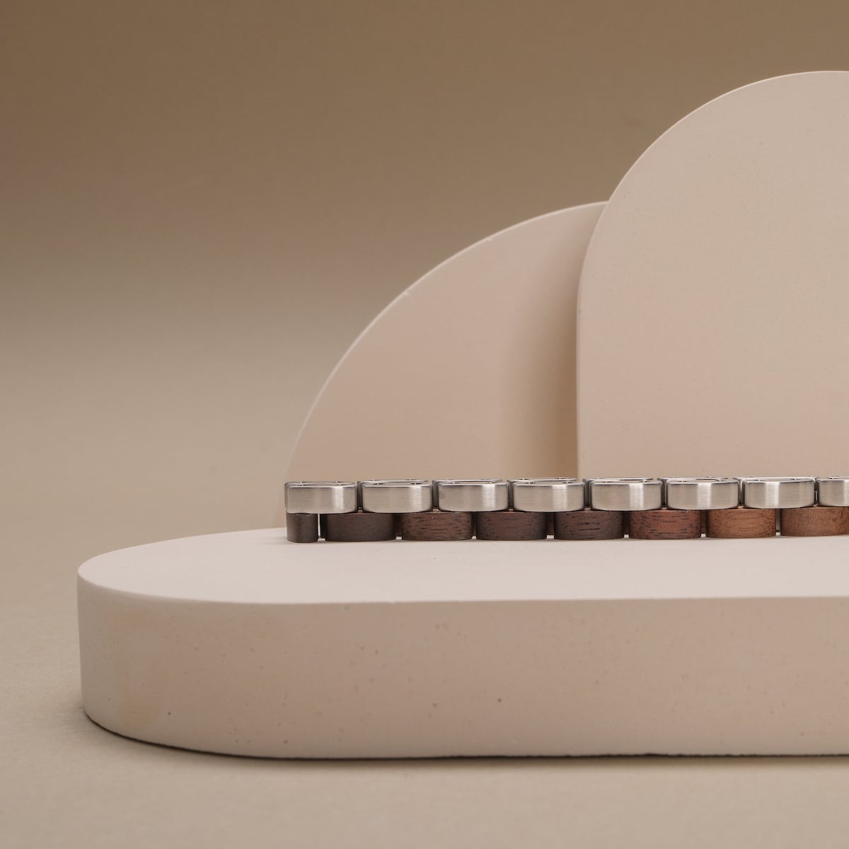 "Duet", a stylish product featuring walnut and silver materials, set against a minimalist beige backdrop.