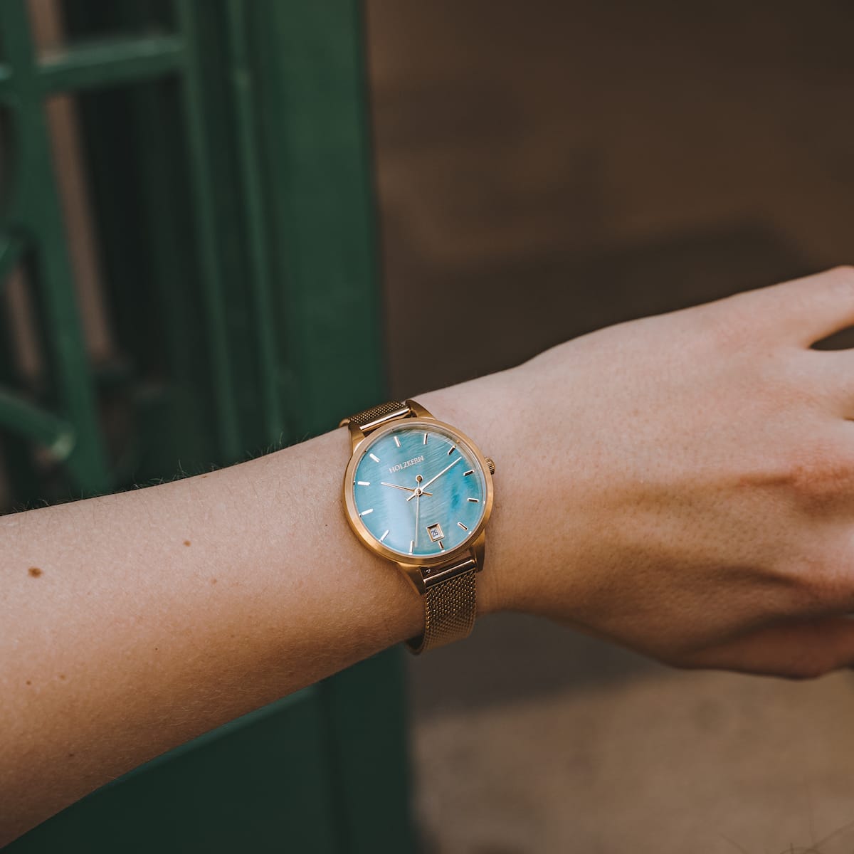 "Talamanca" watch with a turquoise face and gold accents, featuring a sleek and elegant design.
