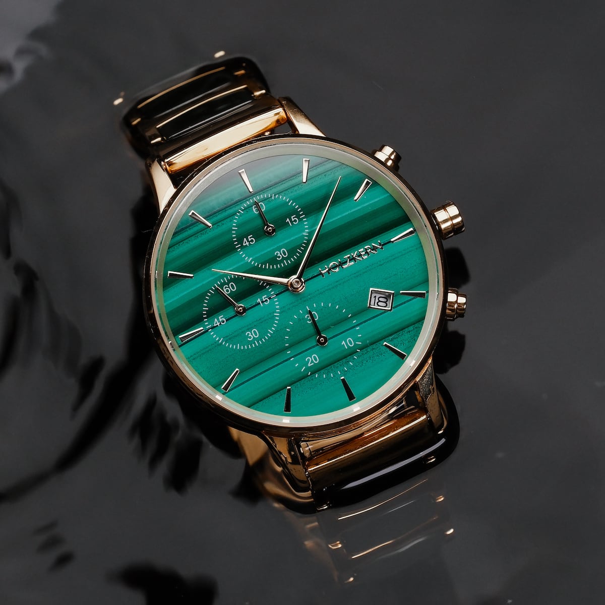 "Jolly" watch with a malachite face and gold accents, featuring a sleek, modern design.