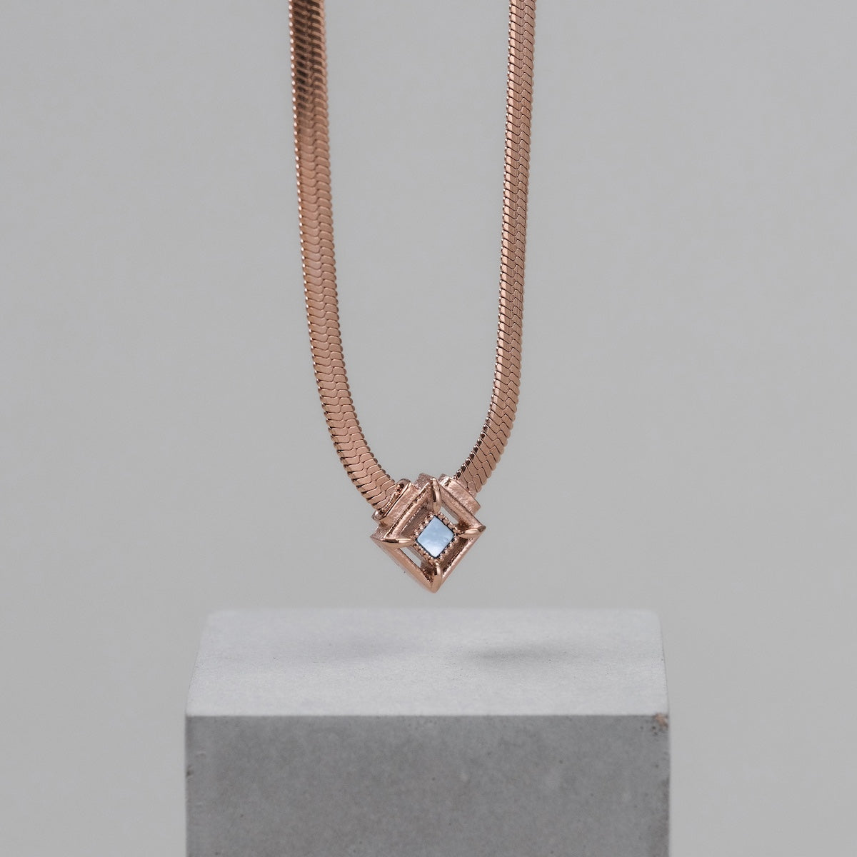 "Awakening Necklace", a rose gold necklace with a modern, geometric design.
