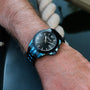 "Glaciersurge" watch, featuring a sleek, modern design with a dark face and blue-steel accents.