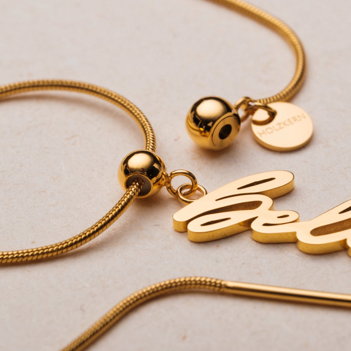 "Believe-Charm", a gold and pearl charm bracelet with an elegant and sophisticated design.