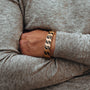 "Baritone" bracelet featuring a sleek maple and gold design on a folded-arm pose.