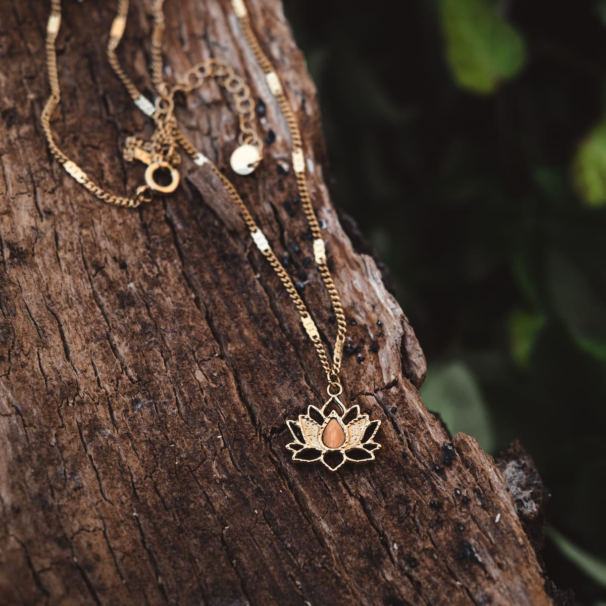 "Balance Necklace", a gold necklace with olive-toned elements, featuring an elegant lotus pendant design.