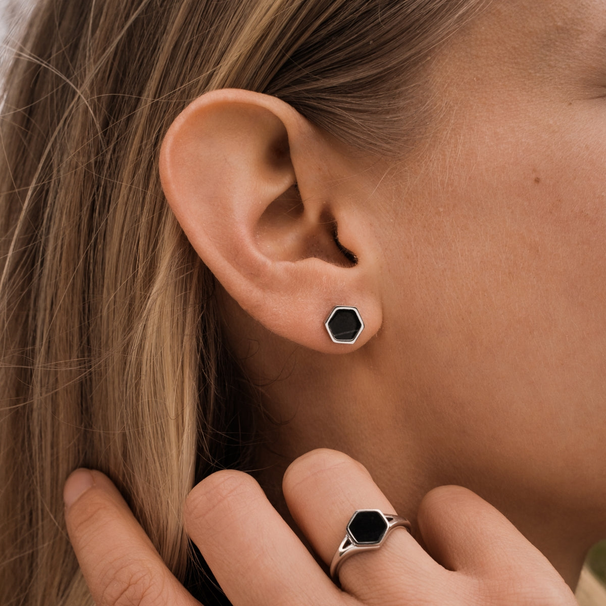 "Facade Earrings" earrings in a hexagonal marble design with silver accents, reflecting a modern, minimalist style.