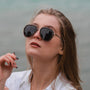 "The Honorable" sunglasses featuring a sleek leadwood and silver design, worn stylishly.
