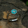 "Spectral Ring", a silver and nacre ring showcasing a turquoise floral design on a textured band.