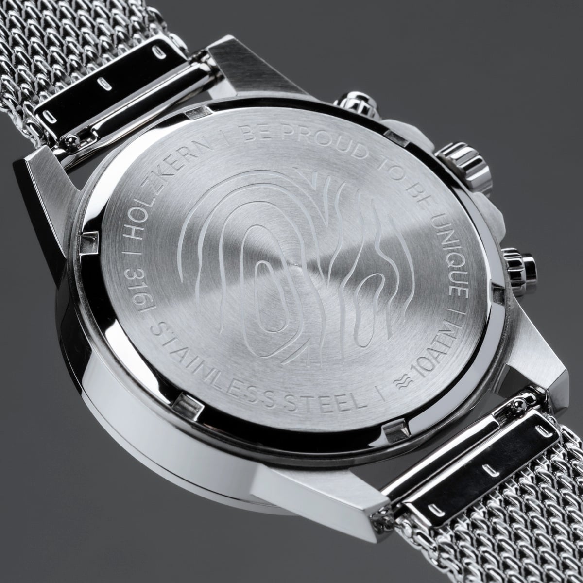 "Comfort Crusher", a sleek wristwatch in maple and silver tones, with a detailed engraved back and a mesh strap.