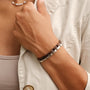 "Duet" bracelet featuring a walnut and silver design, worn fashionably on a wrist.