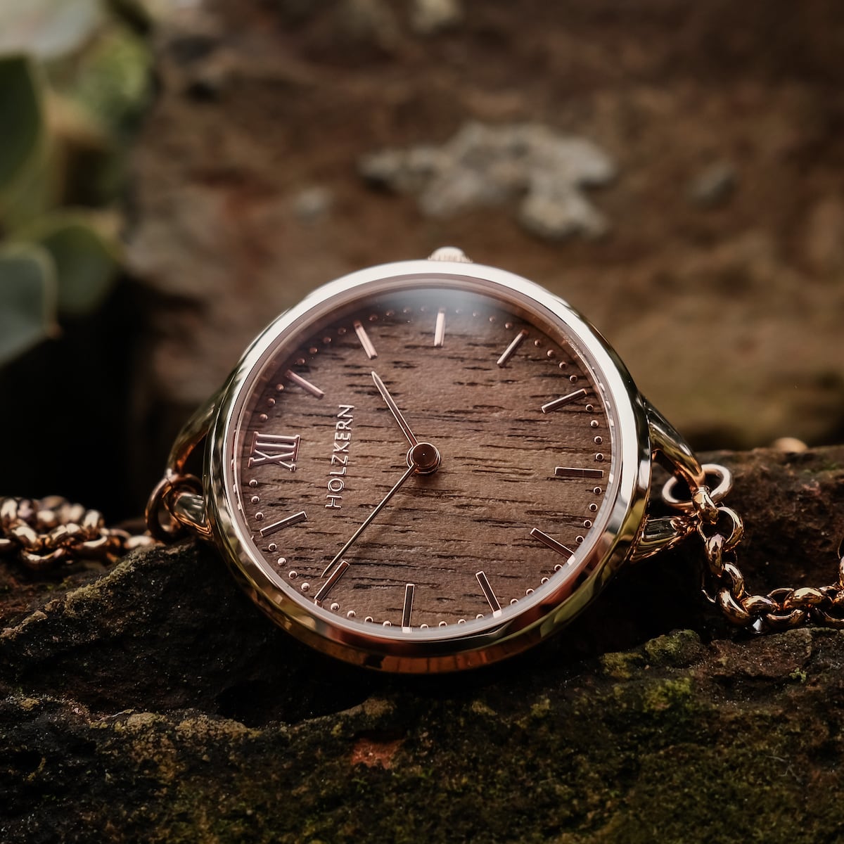 "Blissed" watch with Walnut wood and rose gold accents on a rustic background.