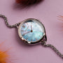 "Brighter" watch featuring a nacre face and silver accents on a vibrant purple background.