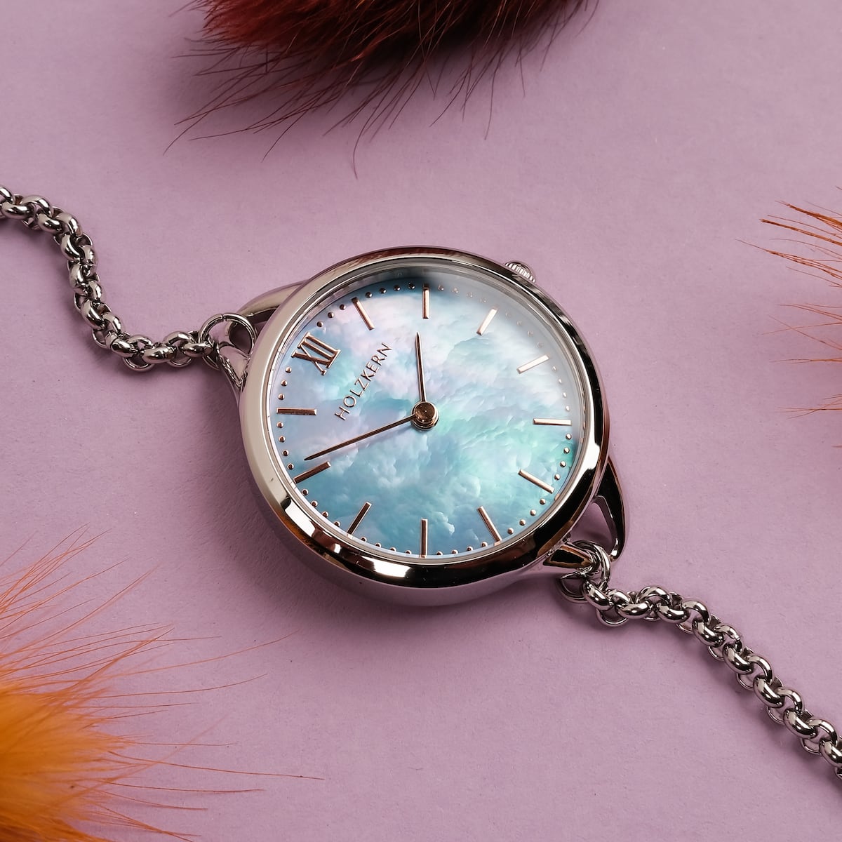 "Brighter" watch featuring a nacre face and silver accents on a vibrant purple background.