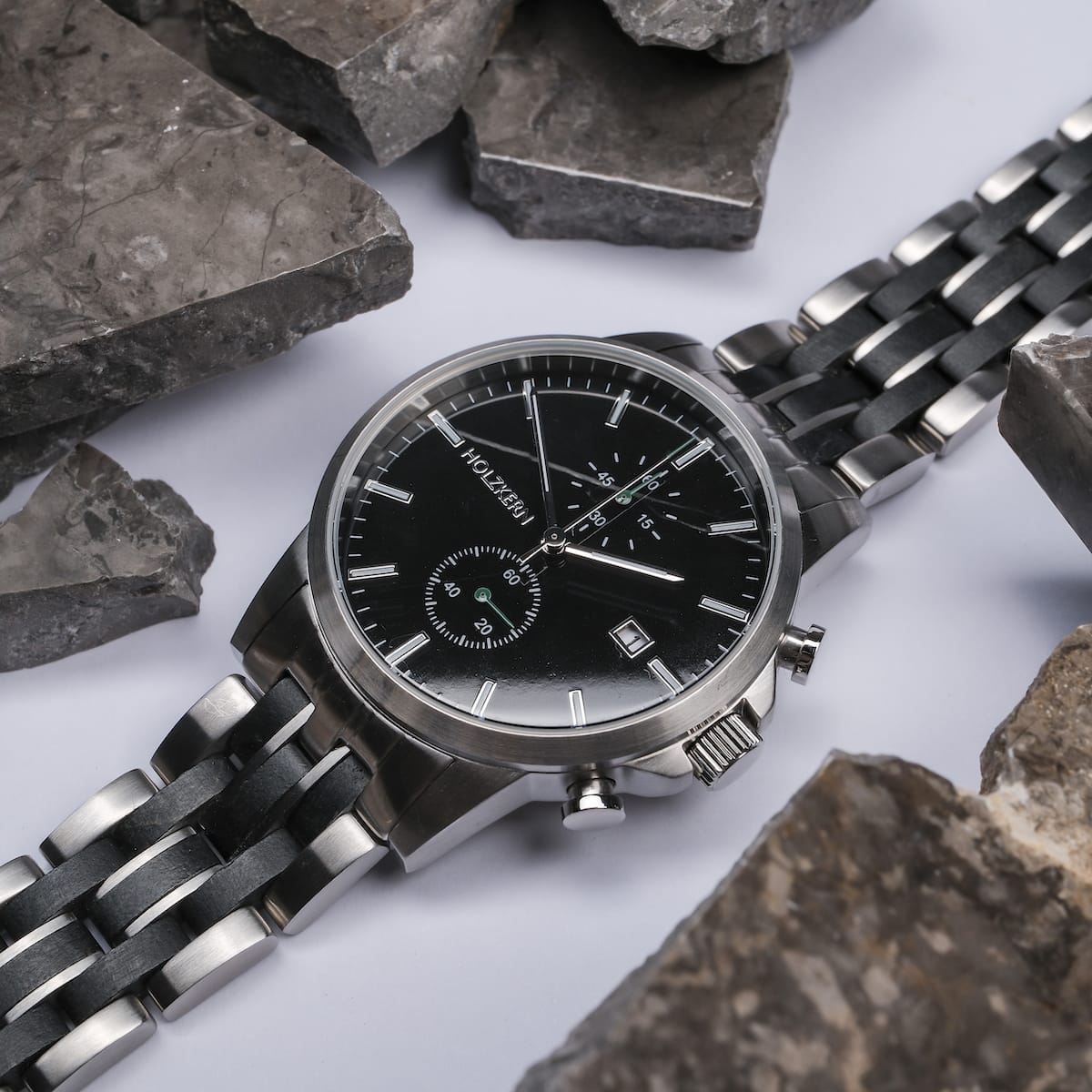 "The Observant wristwatch with maple and marble accents, featuring a sleek, modern design against a rugged stone background."