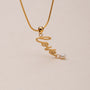 "Love-Charm" necklace featuring elegant gold chain and love charm with pearl accent.
