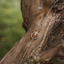 "Opacity Bracelet" bracelet featuring a walnut and silver design on a rustic background.