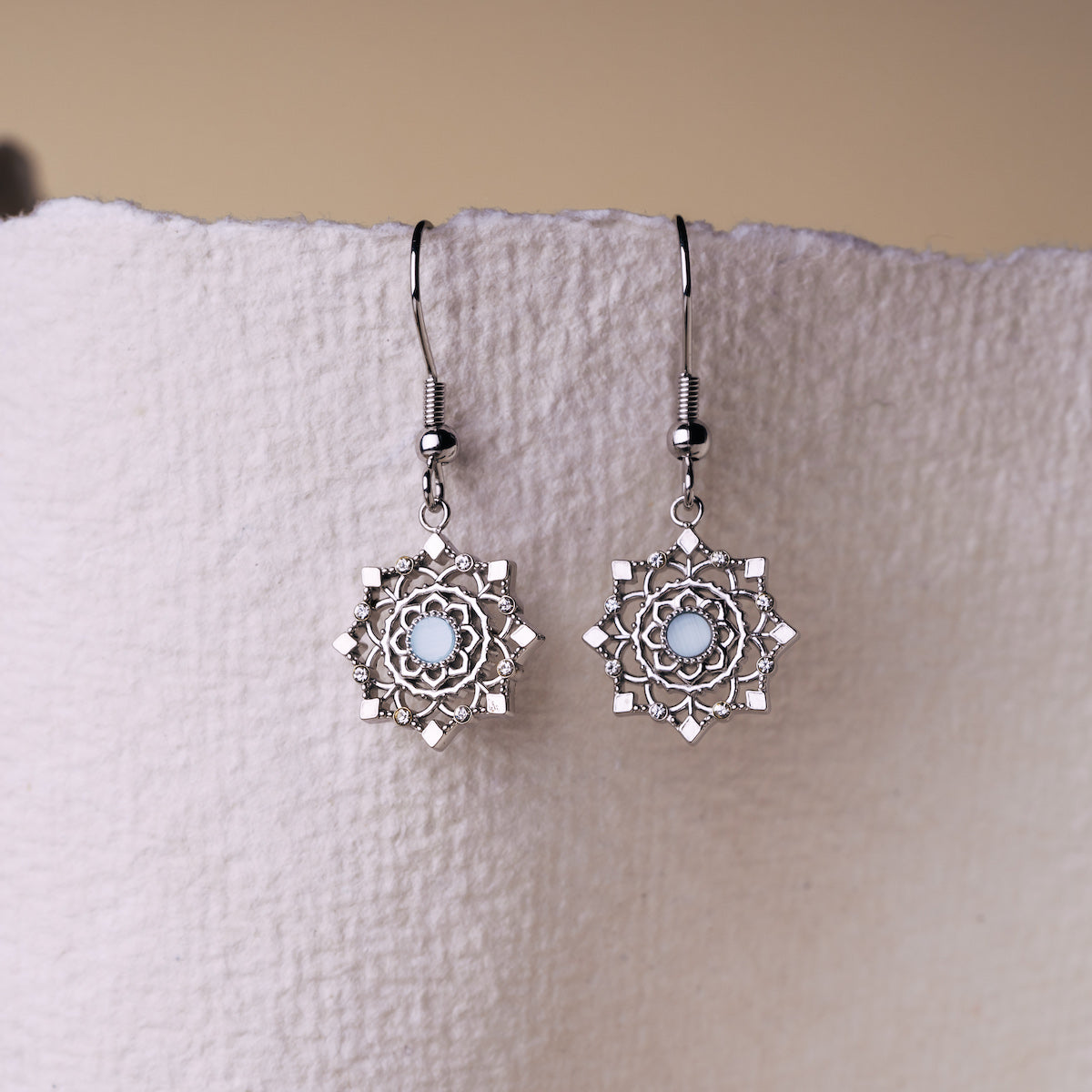 "Aphonia Earrings": Elegant aquamarine and silver earrings with intricate floral design.