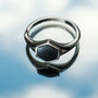 "Facade Ring", a stylish ring featuring a marble and silver design with a reflective and sleek appearance.