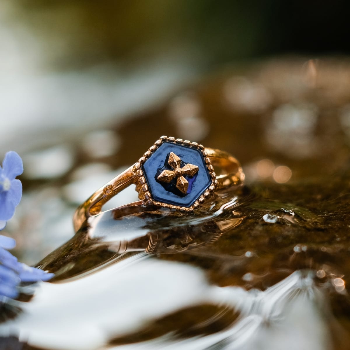 "Spectral Ring", a gold ring with blue nacre inlay, featuring an intricate geometric design.