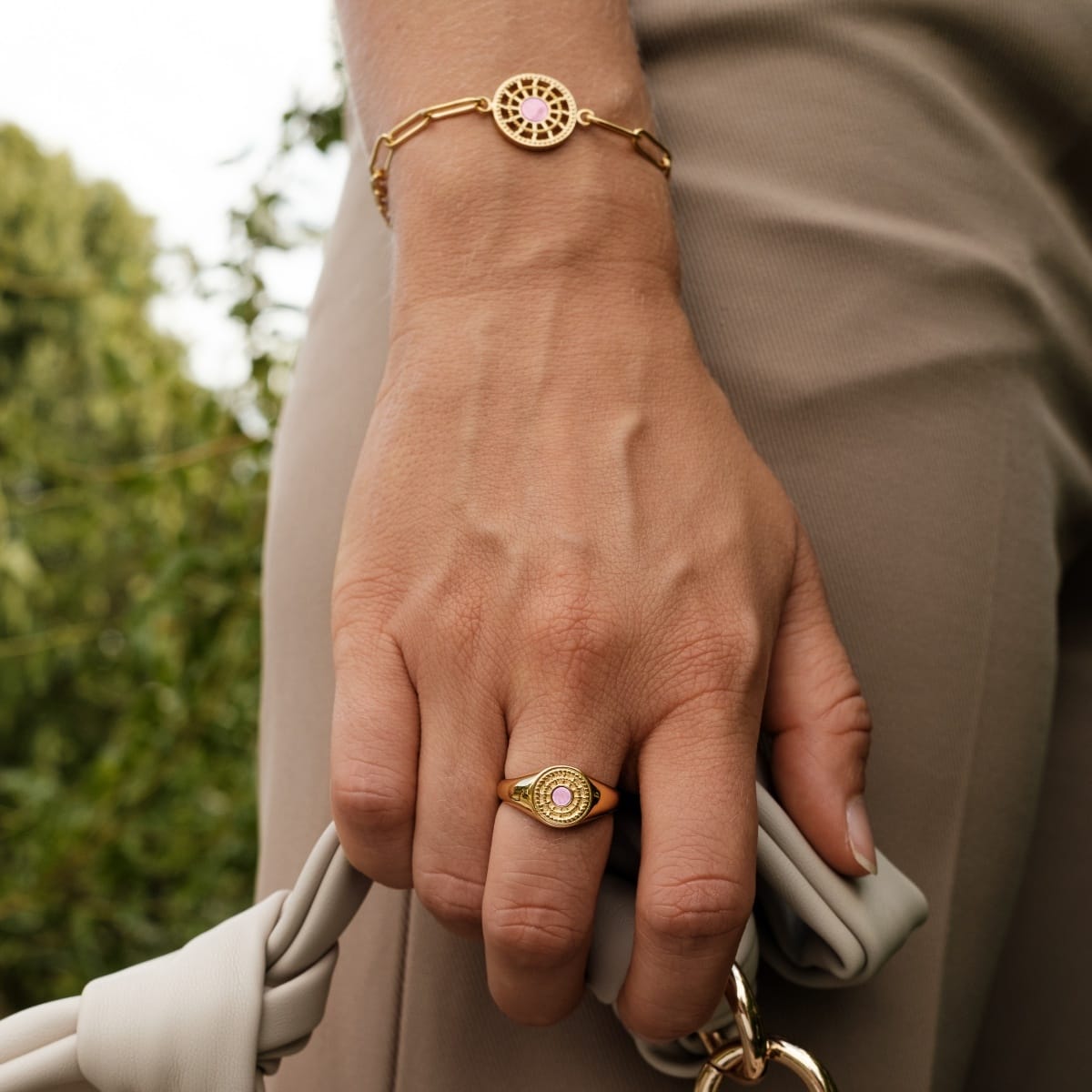 "Pixa Ring", a stylish gold ring with pink nacre, elegantly worn on a hand.