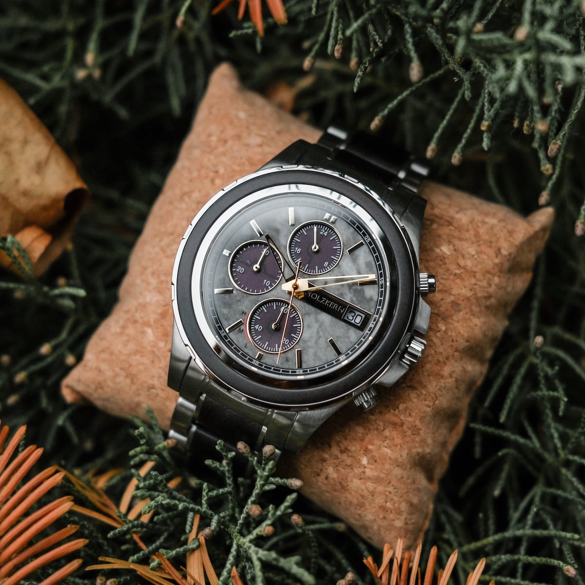 "Cairo" watch featuring a sophisticated maple and marble design, set against a natural green backdrop.